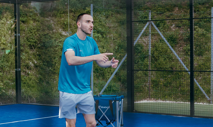 Ein Trainer, der etwas zum Padel Spielen erklärt.